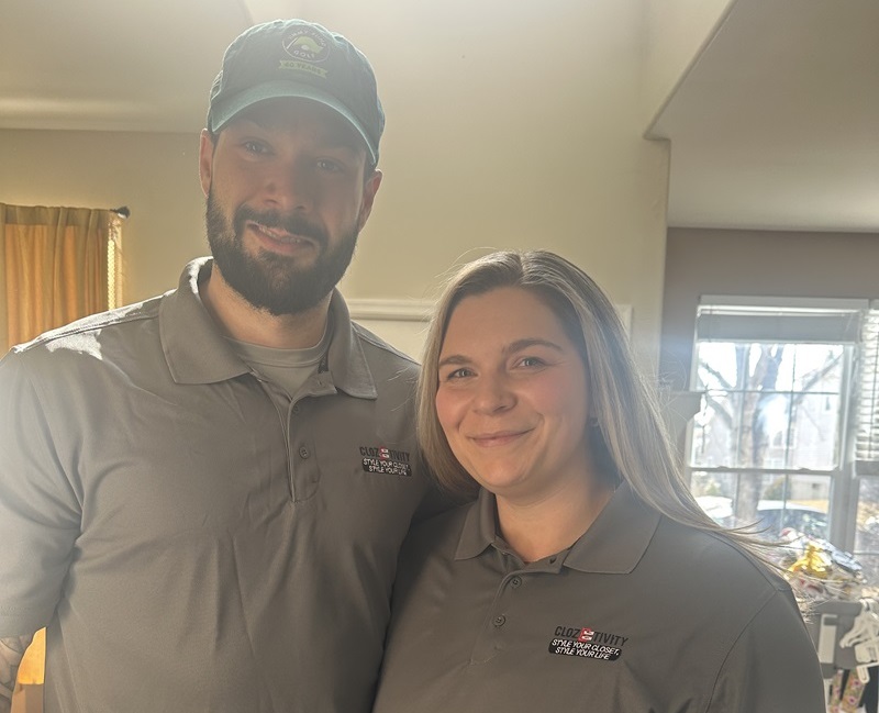 Clozetivity franchise couple smiling in matching gray Clozetivity polo shirts