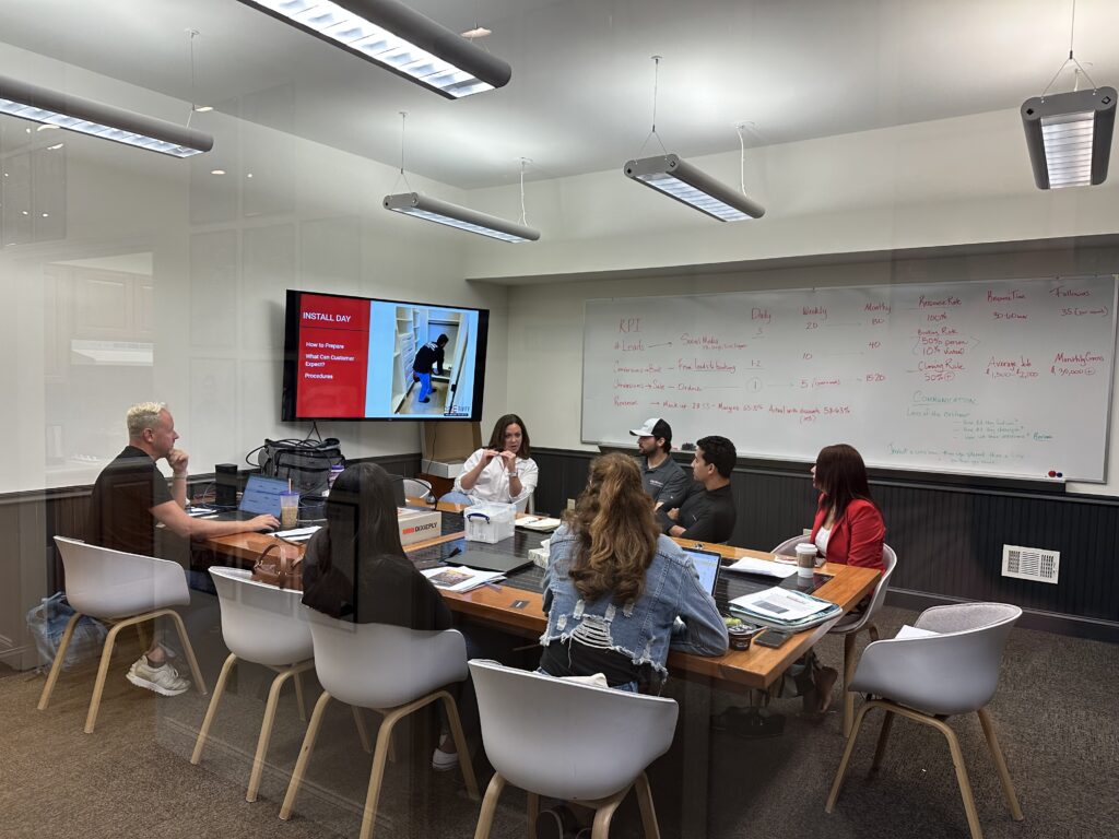 Franchise team in a training meeting with an Install Day presentation on the screen